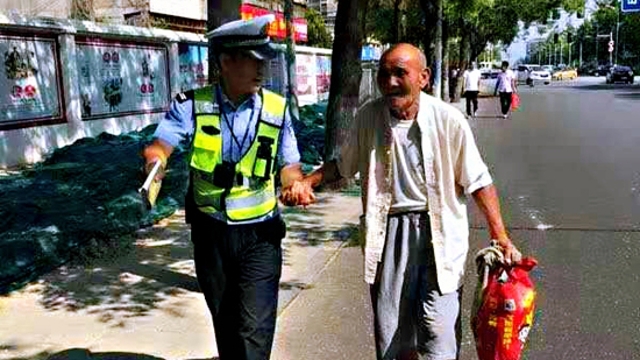 扶老人過(guò)馬路 執勤民警平凡舉動(dòng)暖人心
